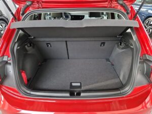 Roter Autokofferraum geöffnet, zeigt leere Ladefläche, grauer Bodenbelag und Gepäcknetz.