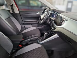 Innenraum eines Autos in Grau mit schwarzen Sitzen, Lenkrad, Schalthebel, moderner Armaturenbrett.
