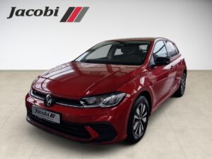Ein roter VW Polo in einem Showroom, Frontalansicht, glänzend lackiert, mit Markenlogo oben links.