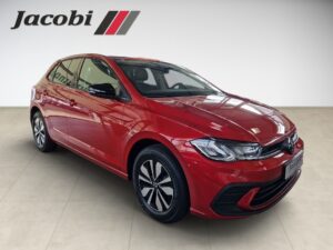 Ein roter Volkswagen mit modernen Linien steht in einem hellen Raum, Logo „Jacobi“ oben links.