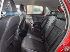 Rückbank eines Autos mit schwarzen Sitzen und roten Akzenten. Keine Personen sichtbar.