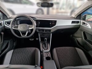 Innenraum eines modernen Autos mit schwarzem und silbernem Armaturenbrett, Lenkrad mit Logo.