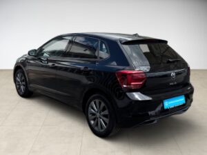Schwarzer Volkswagen Polo, seitliches Profil, auf hellem Boden in hellem Raum.