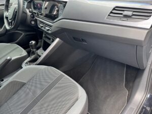 Innenraum eines Autos mit grauen Sitzen und einem manuellen Schalthebel. Modernes Armaturenbrett.