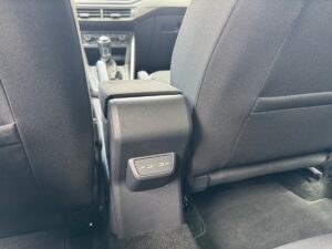 Rücksitz eines Autos mit schwarzen Sitzen und USB-Anschlüssen an der Mittelkonsole.