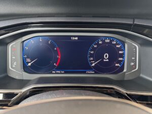Nahaufnahme eines modernen Fahrzeug-Tachometers, Anzeige bei 0 km/h, schwarze und blaue Skala.