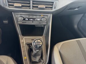 Schaltgetriebe im Auto, schwarzer Innenraum, Klimasteuerung zeigt 20°C an.