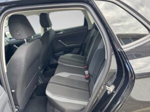 Schwarzer Pkw innen, Rücksitzansicht, graue Polster, Kopfstützen, dunkles Interieur, Tageslicht.