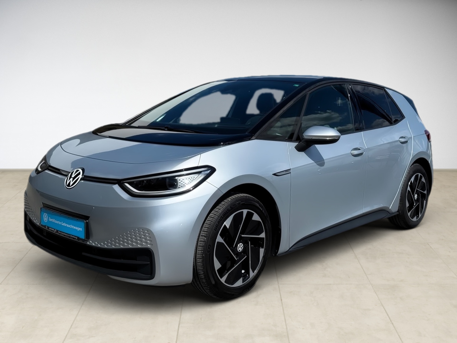 Silberner Volkswagen ID.3 mit schwarzem Dach, seitliche Ansicht, moderne Scheinwerfer und Felgen.