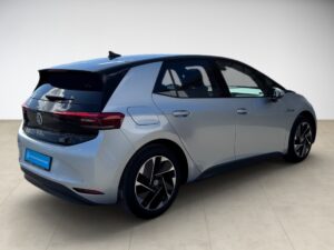 Silbernes Auto mit schwarzem Dach, modernes Design, parkend auf hellem Boden.