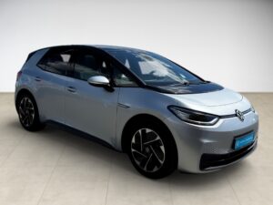 Silberner VW E-Auto mit modernen Scheinwerfern, schwarze Fenster, elegante Ausführung.