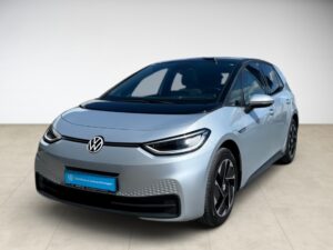 Ein silberner Volkswagen ID.3 in einem Showroom, Vorderansicht, moderne LED-Scheinwerfer.
