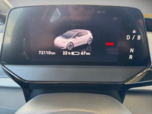 Digitales Display eines Autos, zeigt Reichweite, Kilometerstand und Parkstatus, mit Autoabbildung.