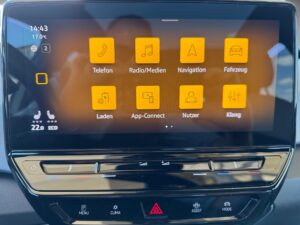 Autoinfotainmentsystem mit orangefarbenen Symbolen: Telefon, Radio, Navigation, Fahrzeug.