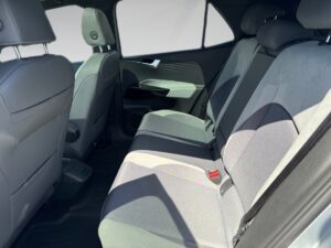 Rücksitze eines Autos mit grauen Stoffbezügen, Klappsitze und viel Tageslicht einfallend.