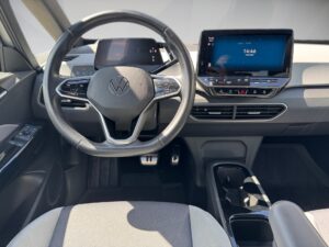 Innenraum eines VW-Autos mit digitalem Display und einem grauen Lenkrad.