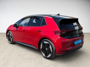 Roter, moderner VW-Hatchback mit glänzendem Finish auf beige Fliesen.