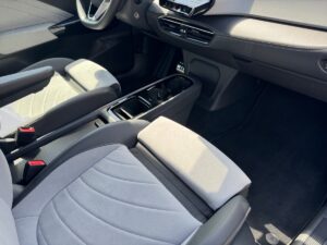 Innenraum eines Autos mit grauen Sitzen, Mittelkonsole und Lenkrad, bei hellem Sonnenlicht.