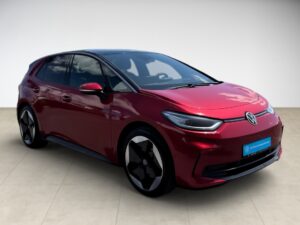 Ein glänzendes, rotes Auto mit modernem Design, glänzenden Scheinwerfern und schwarzen Akzenten.