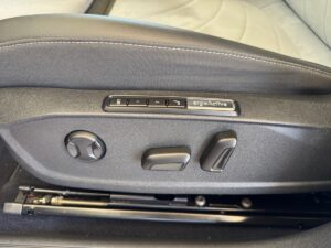 Autositzeinstellung mit Tasten zur Steuerung und grauer Polsterung.