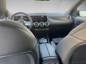 Ansicht eines modernen Fahrzeuginnenraums mit Leder, schwarzen Sitzen und stilvollem Armaturenbrett.