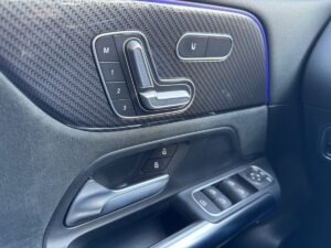 Autotür-Innenverkleidung mit verstellbarem Sitzregler, Fensterknöpfen und kohlefaserartigem Muster.