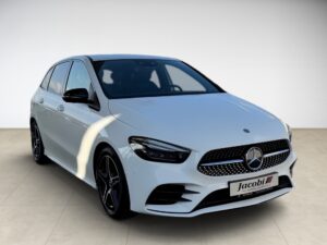 Weiße Mercedes B-Klasse, Frontansicht, auf hellem Boden, mit blau abgedunkelten Fenstern.