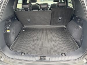 Kofferraum eines Autos mit schwarzen Sitzen und einer schwarzen Gummimatte.