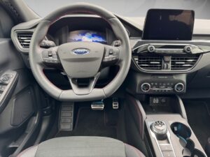 Innenansicht eines Ford-Autos mit lenkendem Steuer und Infotainment-Bildschirm.