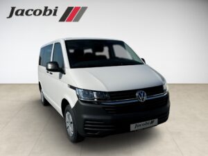 Ein weißer VW-Transporter mit Jacobi-Logo auf beigem Boden, frontal leicht seitlich gezeigt.