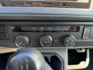 Auto-Klimasteuerung, schwarze Bedienknöpfe und Schaltknauf, kein sichtbares Display.