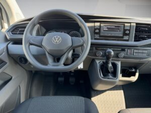 Lenkrad eines Volkswagens, graue Armaturen, Schalthebel; klare Instrumentenanzeige.