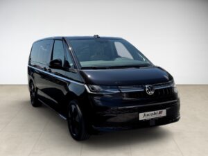 Schwarzer VW-Bus in einem hellen Raum, Frontansicht, mit glänzendem Lack und abgedunkelten Scheiben.