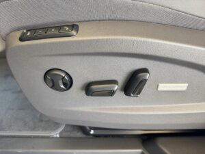 Autositzeinstellungen in Beige mit Tasten und Hebeln für Anpassung, detailreiche Nahaufnahme.