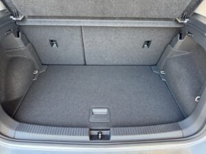 Grauer, leerer Kofferraum eines Autos mit hochgeklappter Hutablage.