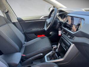 Innenraum eines Autos, schwarzer Stoff und Armaturenbrett, modernes Design, rotes Detail vorne.