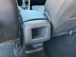 Auto-Innenraum, dunkle Polsterung, Sicht auf Rückseite der Mittelkonsole mit Lüftungsschlitzen.