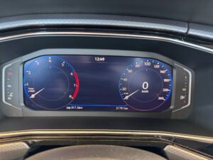 Digitales Armaturenbrett im Auto, zeigt 0 km/h. Anzeigen in blau und rot, moderne Ästhetik.