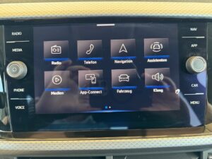 Nahaufnahme eines Autodisplays mit verschiedenen Menüsymbolen in einem modernen Fahrzeug.