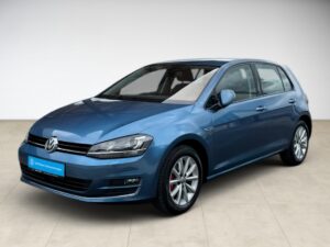 Blauer VW Golf in einem hellen Raum, seitliche Ansicht von vorne.