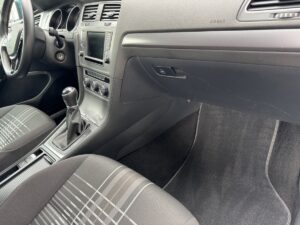 Innenraum eines Autos: Schalthebel, Armaturenbrett mit Anzeige, grauer Stoff.