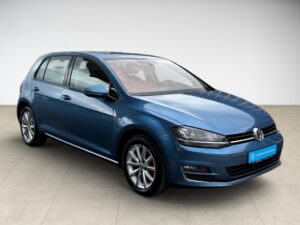 Blauer VW Golf mit glänzender Karosserie, seitlich fotografiert; keine Personen sichtbar.