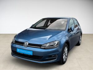Ein blauer Volkswagen Golf mit glänzendem Lack, frontal fotografiert auf hellem Boden.