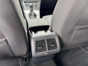 Auto-Innenraum: Rückseite der Mittelkonsole mit Lüftungsschlitzen in schwarz, neutraler Ausdruck.