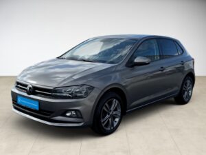 Grauer Volkswagen Polo mit glänzendem Lack und schwarzen Felgen, seitliche Ansicht.