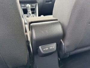 Autoinnenraum mit grauem Stoff, Mittelarmlehne und USB-Anschlüssen.