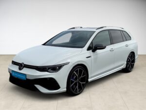 Ein weißer Volkswagen Kombi mit schwarzen Felgen und abgedunkelten Scheiben in einem Studio.