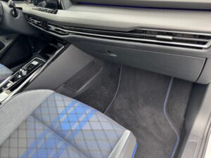 Autoinnenraum mit blau karierten Sitzen, Karbon-Armaturenbrett und mattschwarzen Details.