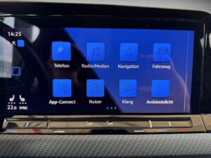 Ein Autodisplay zeigt blaue Symbole für Telefon, Radio, Navigation und mehr.