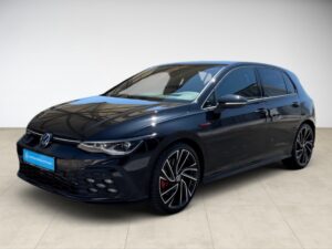 Schwarzer VW Golf mit aggressivem Look und modernen Felgen, steht auf hellem Boden.